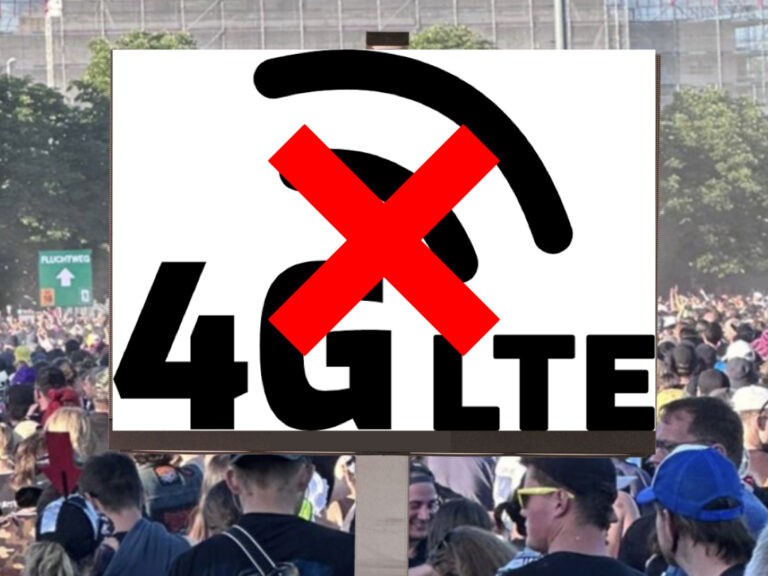A “no mobile signal” sign held up in a dense festival crowd